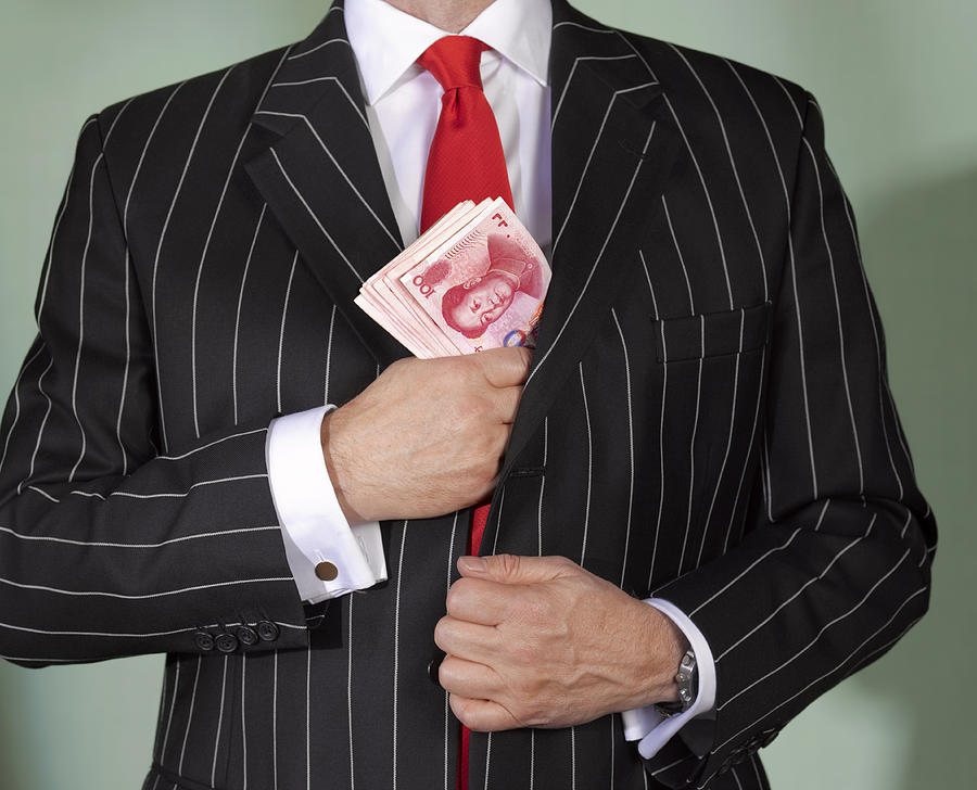Financial advisor with chinese currency Photograph by Peter Dazeley