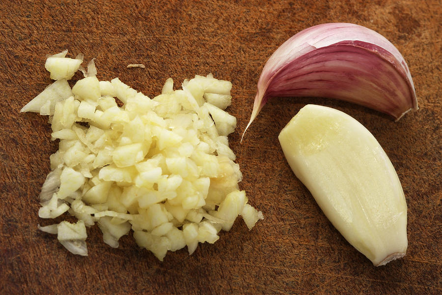 Finely chopped garlic on a wooden cutting board Photograph by KevinDyer