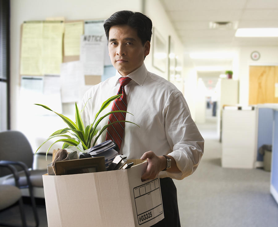 Fired Chinese businessman carrying box of personal items Photograph by Jose Luis Pelaez Inc