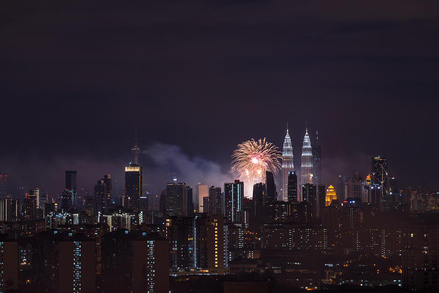 Fireworks explode near Malaysias landmark Petronas Twin Towers during New Year celebrations in Kuala Lumpur Photograph by Shaifulzamri