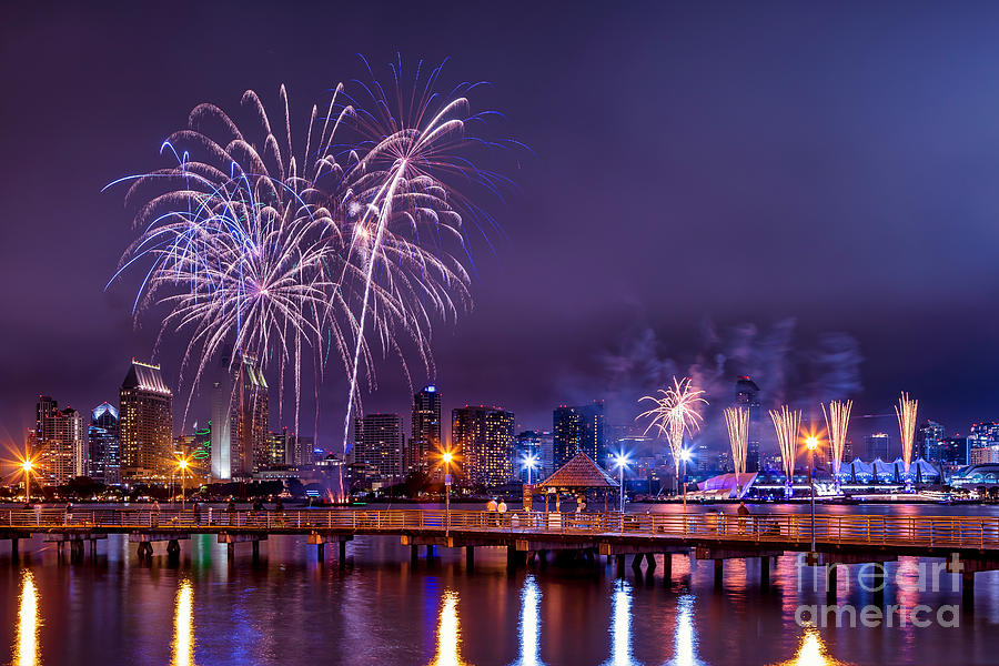 Fireworks over a downtown city skyline along a harbor Photograph by Sam Antonio