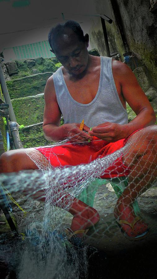 Fisherman repairs the net Photograph by Robert Bociaga