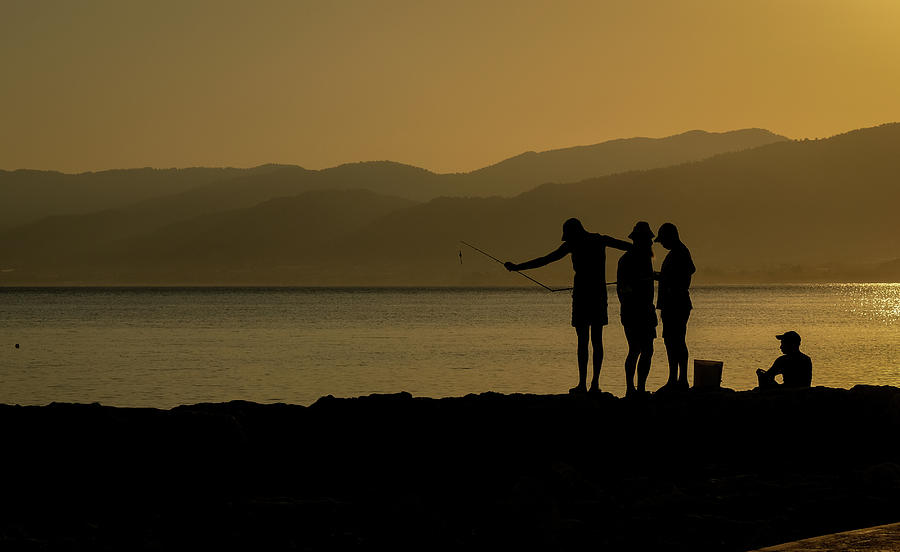 Fishermen silhouette fishing in the coast at sunrice. Photograph by Michalakis Ppalis