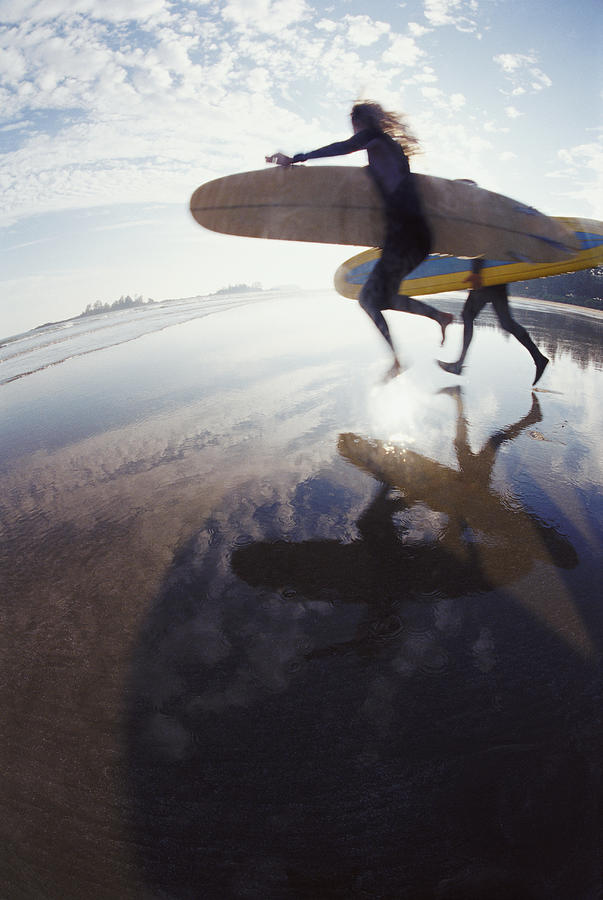 Fisheye Lens Shot of Two Surfers Running Across a Beach, in Silhouette Photograph by Darryl Leniuk