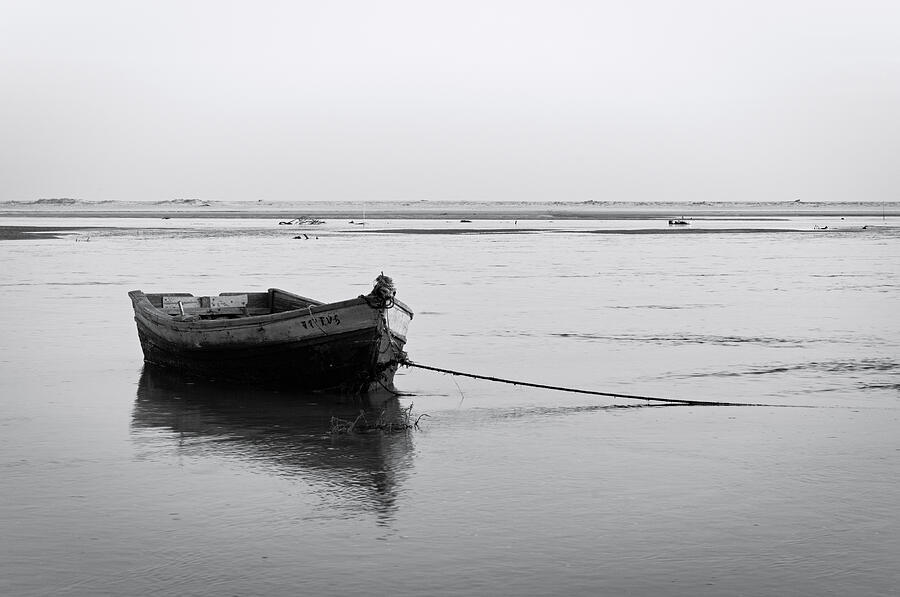 Fishing boat and low tide Photograph by Angelo DeVal