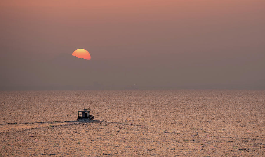 Fishing boat sailing in the sea to catch fish at sunset Photograph by Michalakis Ppalis