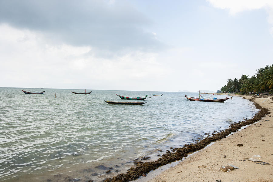 Fishing boats on shore; Photograph by IPGGutenbergUKLtd
