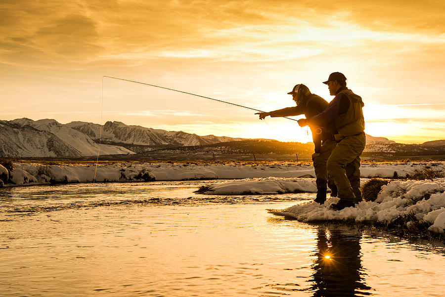 Fishing Guide Pointing Out A Trout At Sunset Photograph by MichaelSvoboda