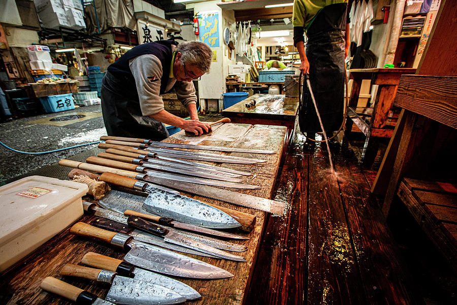 Fishmonger cleaning his knives in Tsukiji Fish Market Photograph by Ruben Vicente
