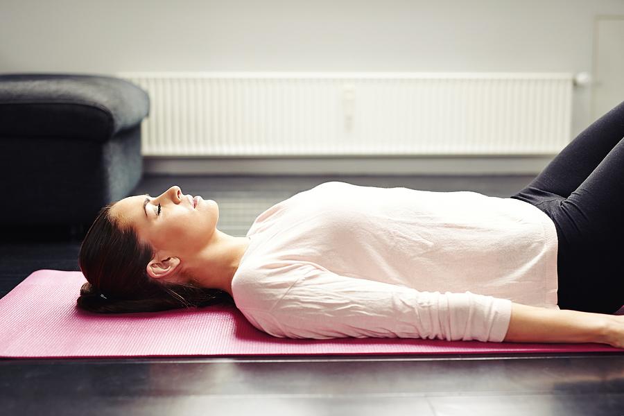 Fit young woman relaxing on yoga mat Photograph by Jacoblund