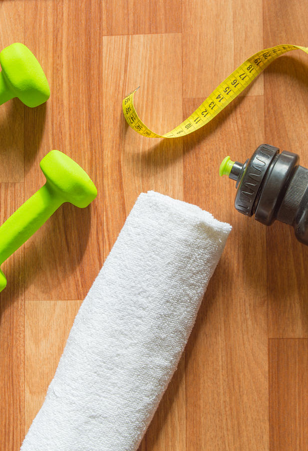 Fitness concept with dumbbells, water bottle, measuring tape, towel on Photograph by ClaireLucia