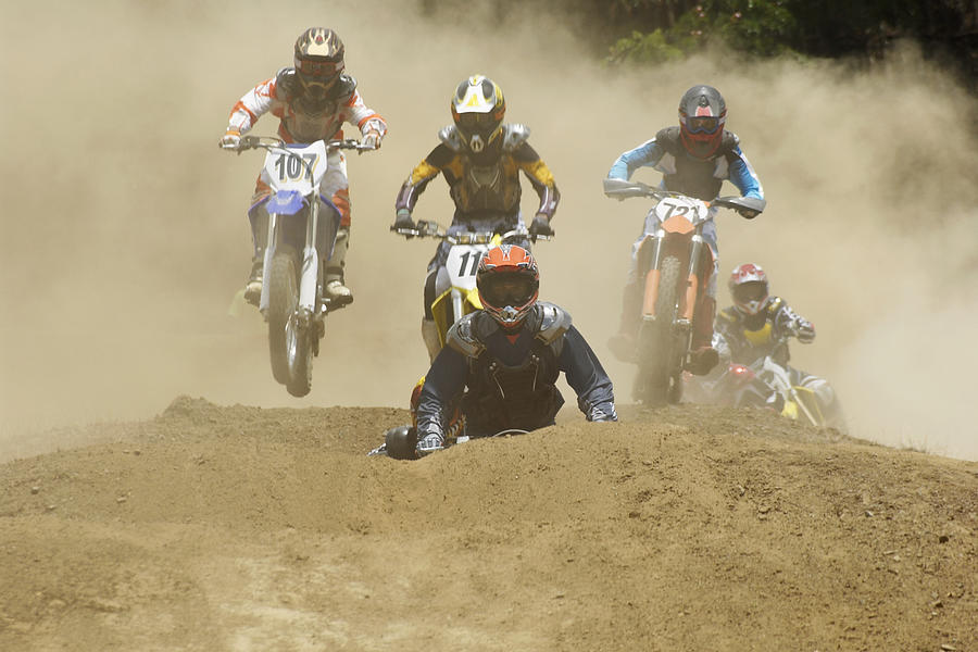 Five motocross riders riding motorcycles on a dirt road Photograph by Glowimages