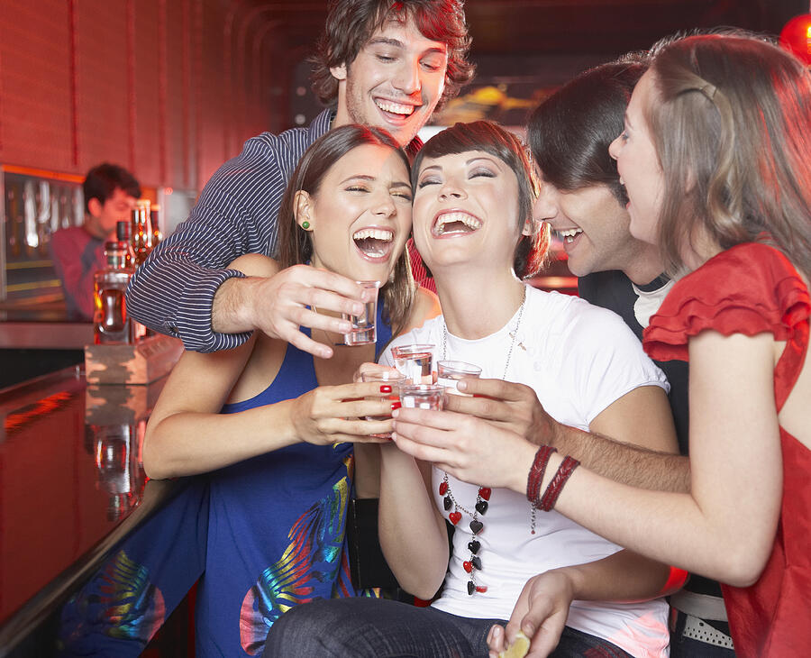 Five people with shots in nightclub toasting and smiling Photograph by Paul Bradbury