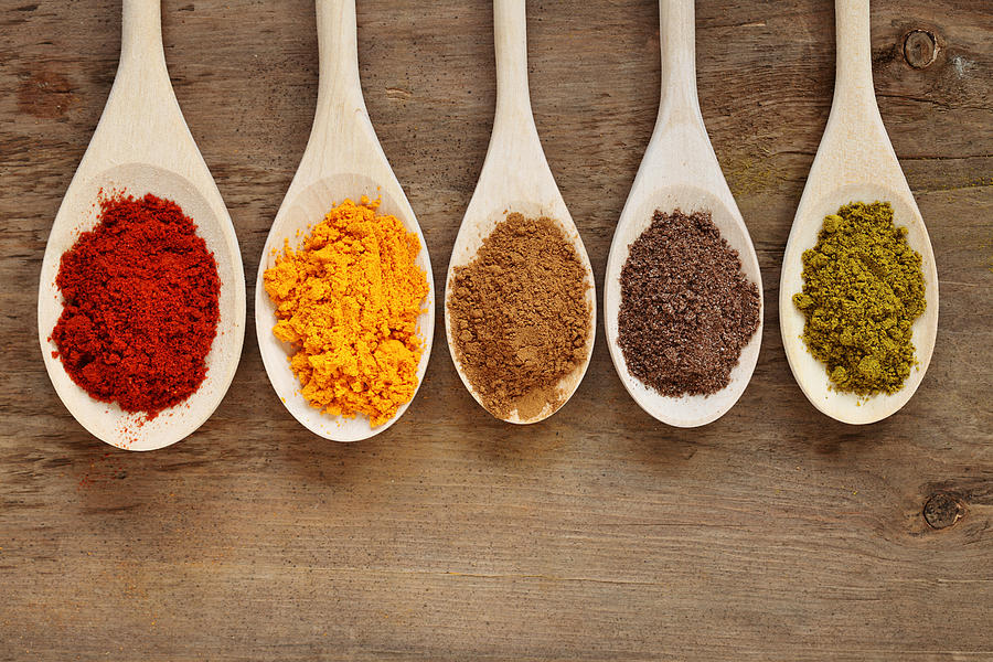 Five spoons with different colored spices Photograph by Luchezar