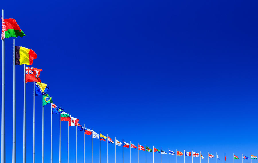 Flags against blue sky Photograph by Nobilior