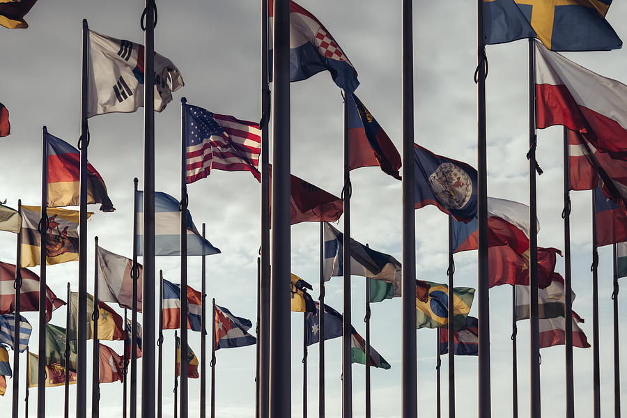 Flags of different nations on high flagpoles Photograph by Oliver Helbig