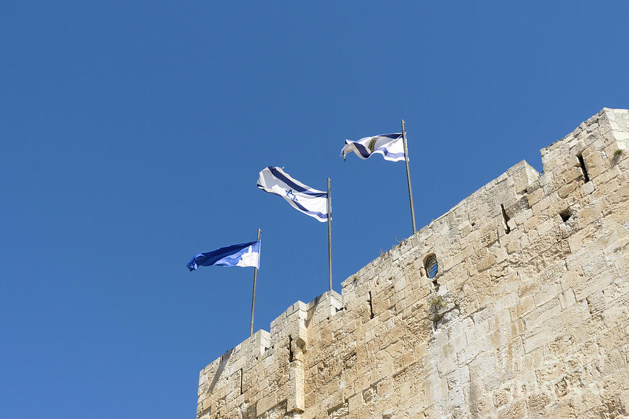 Flags of Israel, Jerusalem and the Citadel fly on a wall of the  Photograph by William Kuta