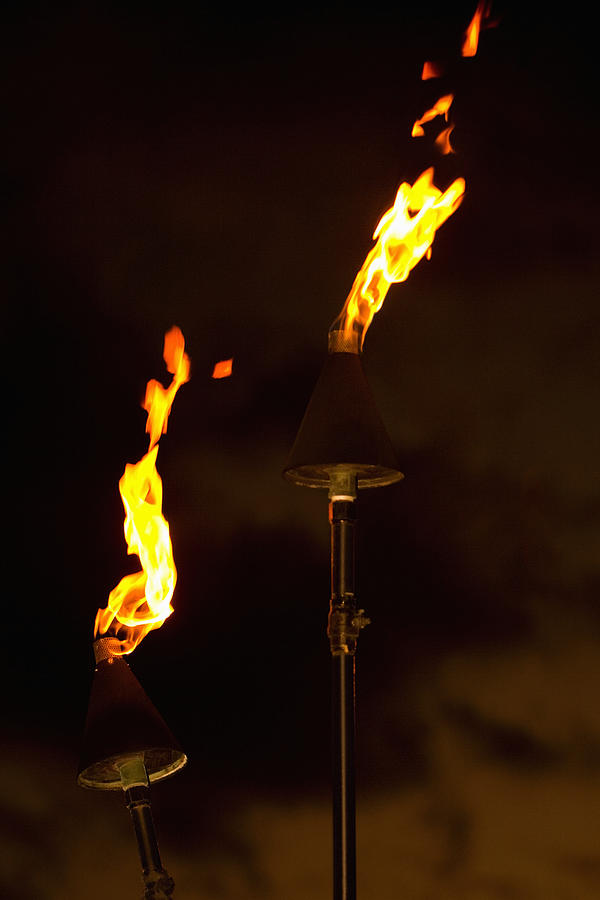 Flame burning from tiki torches Photograph by Glowimages
