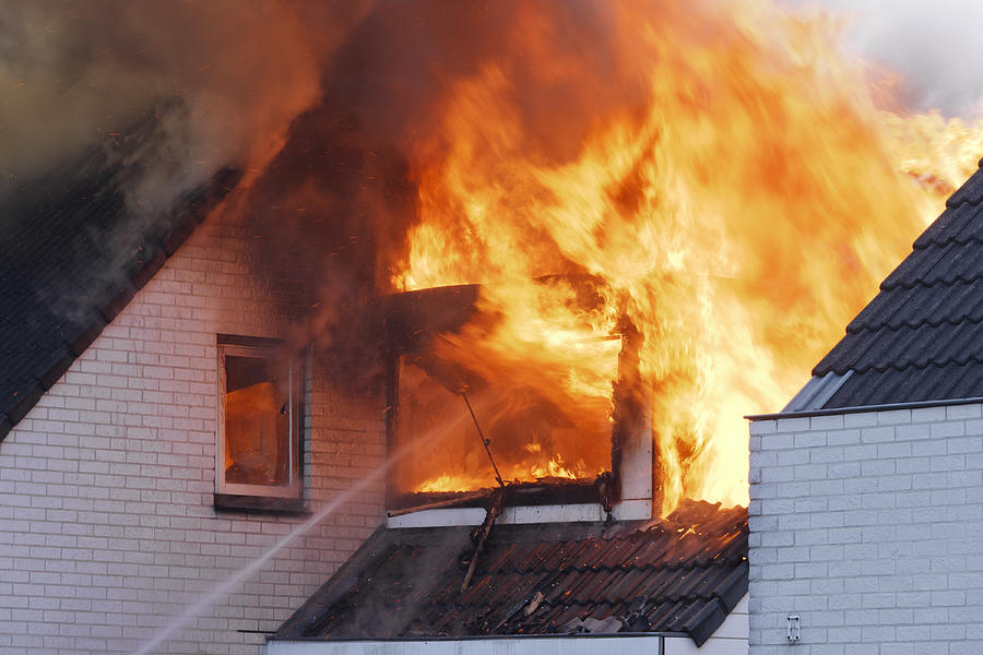 Flames coming out of white brick wall house on fire Photograph by Jaap2