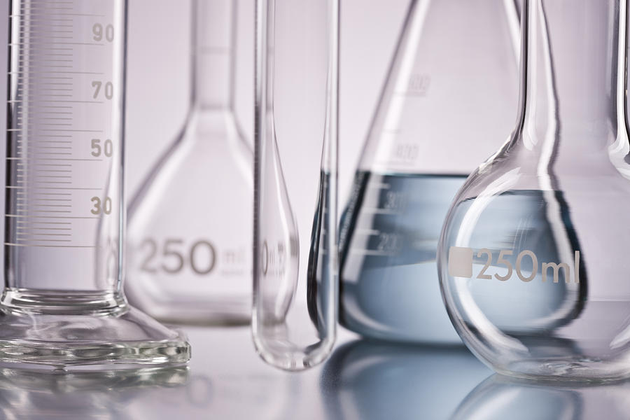 Flask with chemicals and test tubes over isolated background Photograph by Neustockimages