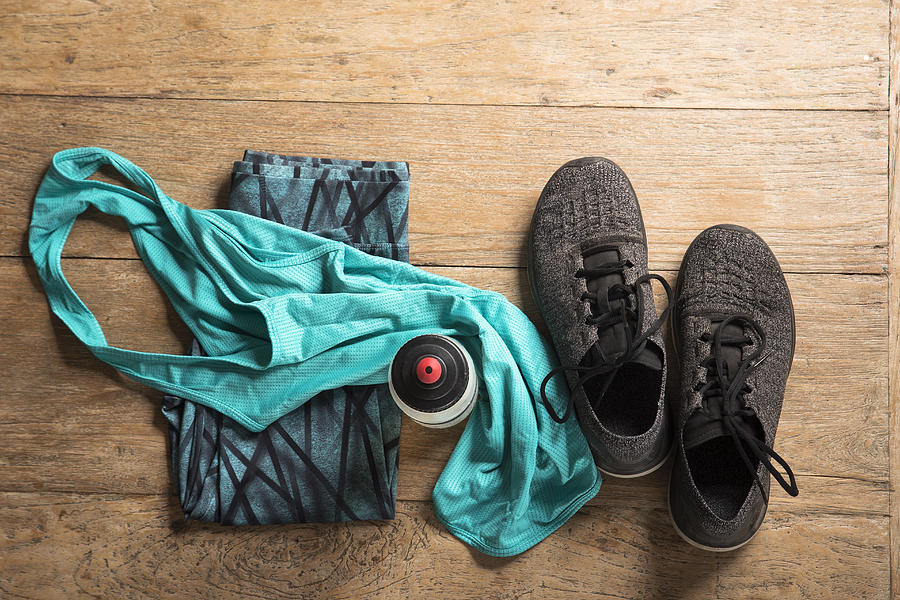 Flat Lay image of sports clothes and shoes on a wooden floor. Photograph by Jenner Images
