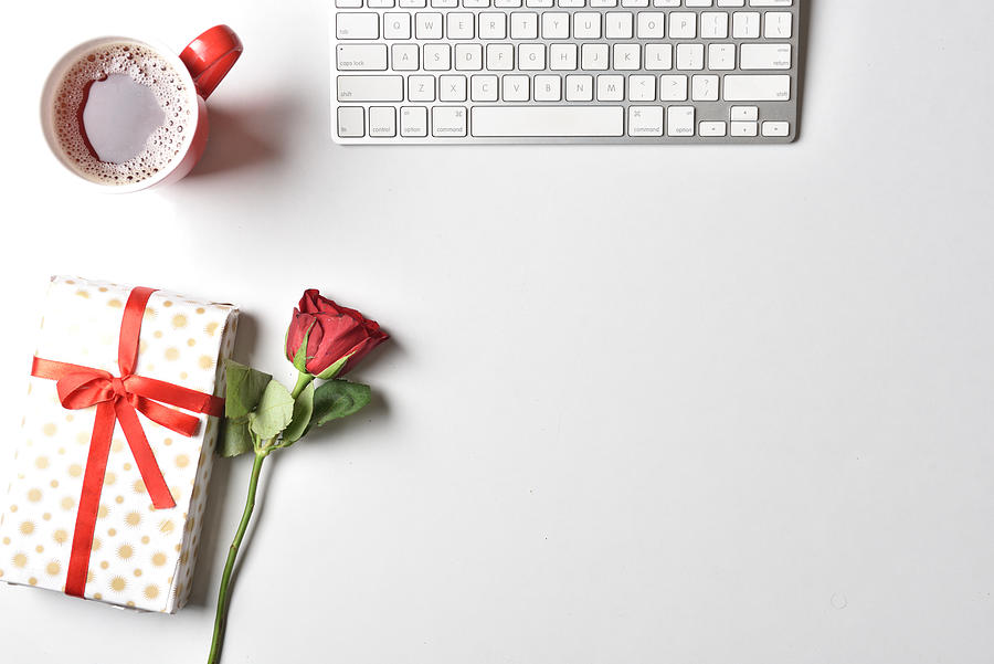 Flat lay Valentines Day background with computer keyboard, gift, coffee mug and red tulip top view white copy space Photograph by Copyrights @ Arijit Mondal