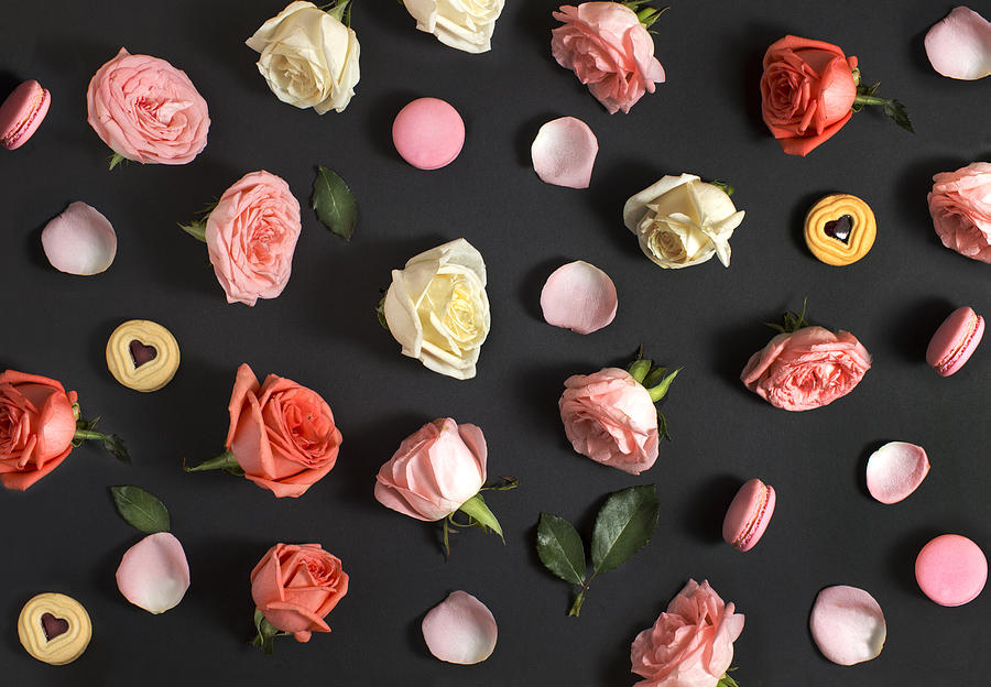 Flay lay roses and macaroon on black background. Photograph by Twomeows