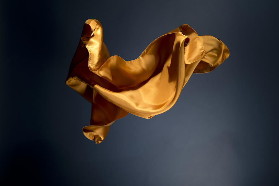 Floating yellow satin on a dark blue background Photograph by Brightstars