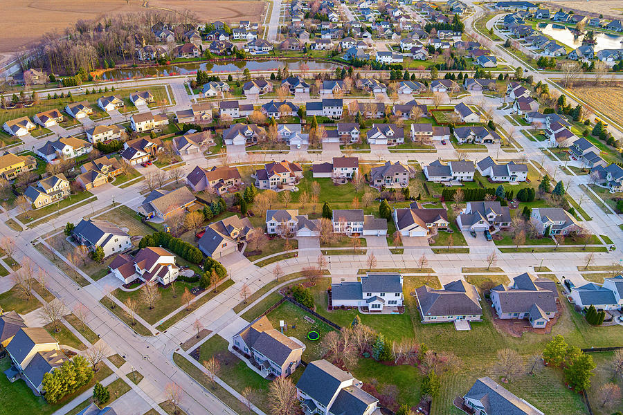 Flying above beautiful suburb neighborhood on a Springtime morning ...