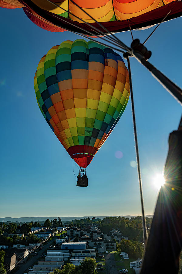 Flying hot air balloon with sunburst Photograph by Dan Friend