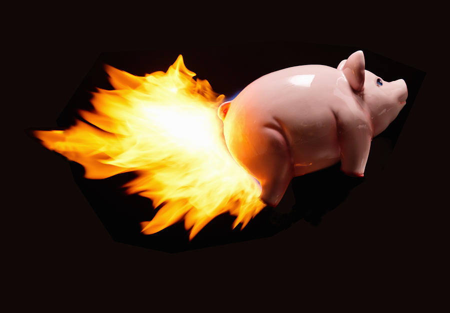 Flying piggy bank on fire Photograph by PM Images