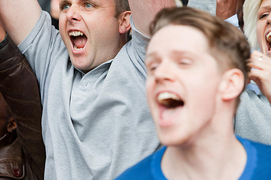Football fans cheering Photograph by Image Source