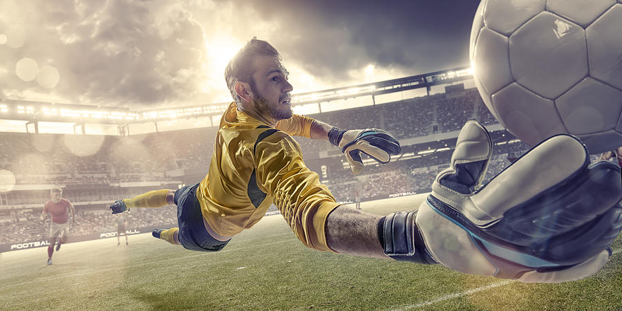 Football Goalkeeper Diving To Save Ball During Soccer Match Photograph by Peepo
