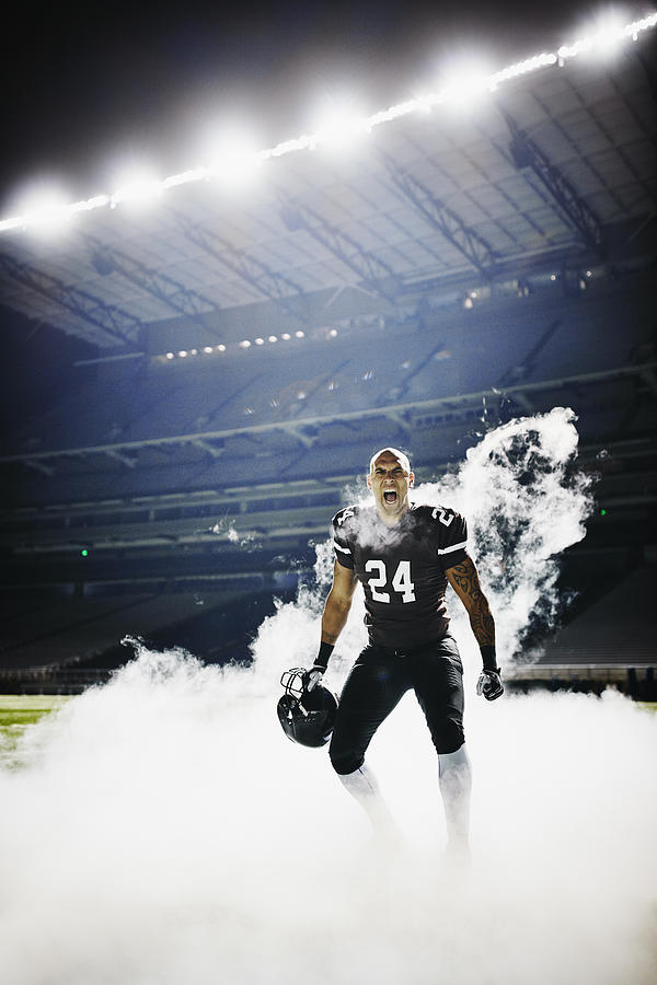 Football player standing on field in fog screaming Photograph by Thomas Barwick