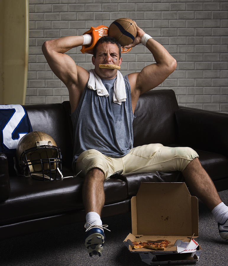 Football player with pizza in mouth looking frustrated Photograph by Hill Street Studios