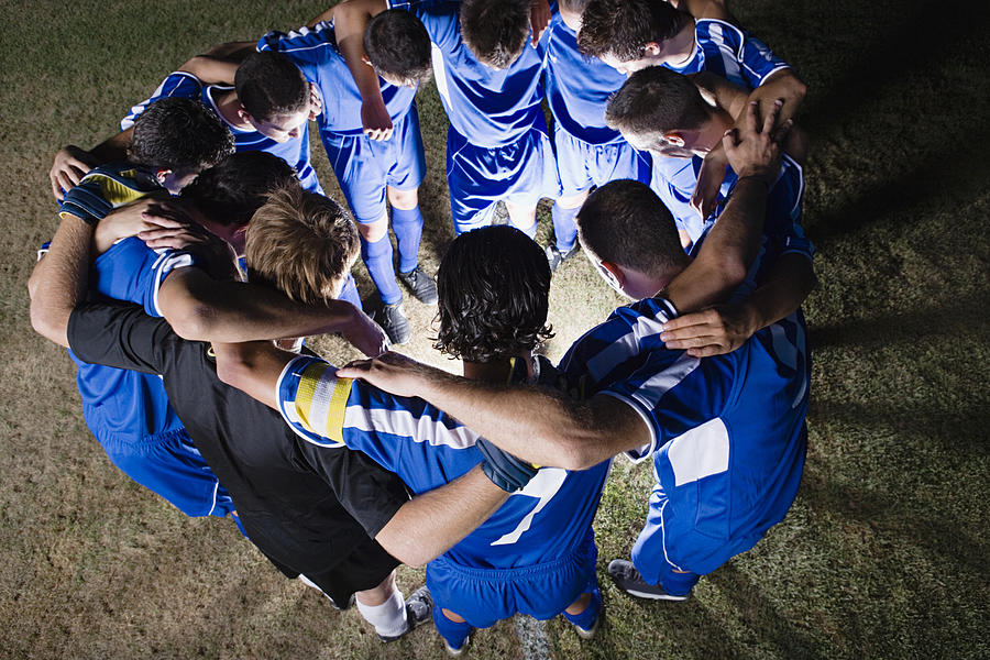 Football team in a huddle Photograph by Image Source