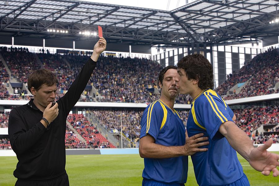 Footballer arguing with a referee Photograph by Image Source
