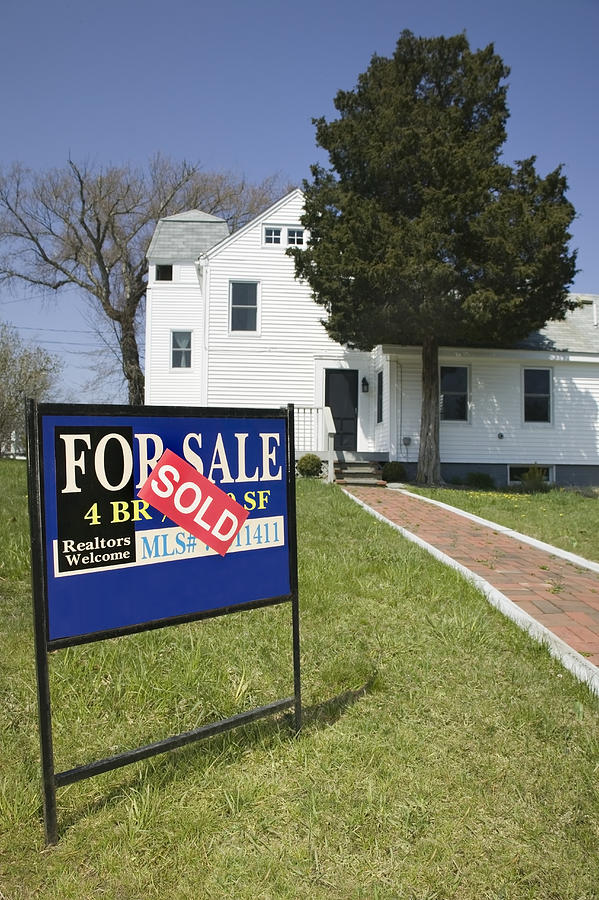 For Sale sign on lawn in front of house Photograph by Steve Wisbauer