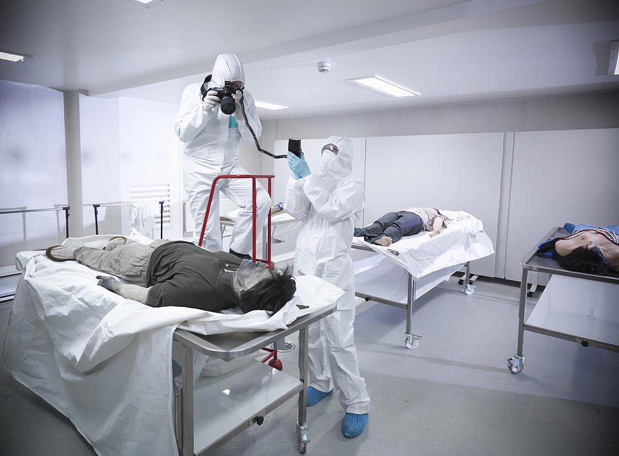 Forensic scientist photographing artificial body in mortuary at training facility Photograph by Monty Rakusen