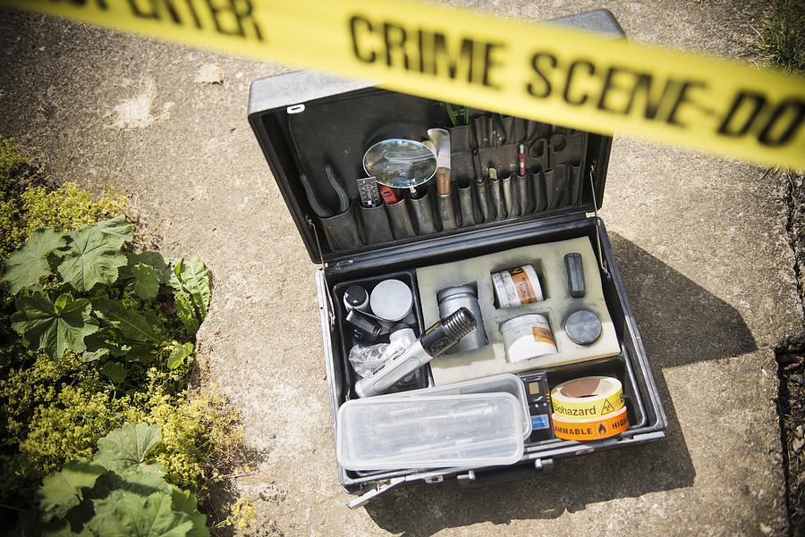 Forensic toolkit at crime scene with police tape Photograph by Monty Rakusen