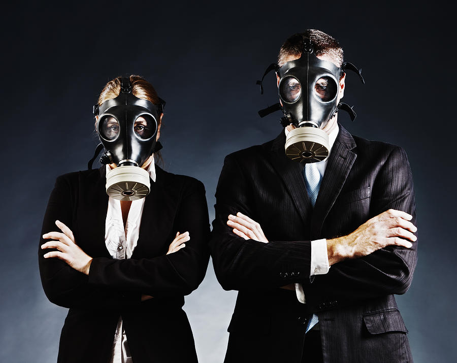 Formally dressed couple in gas masks fold arms and stare Photograph by RapidEye