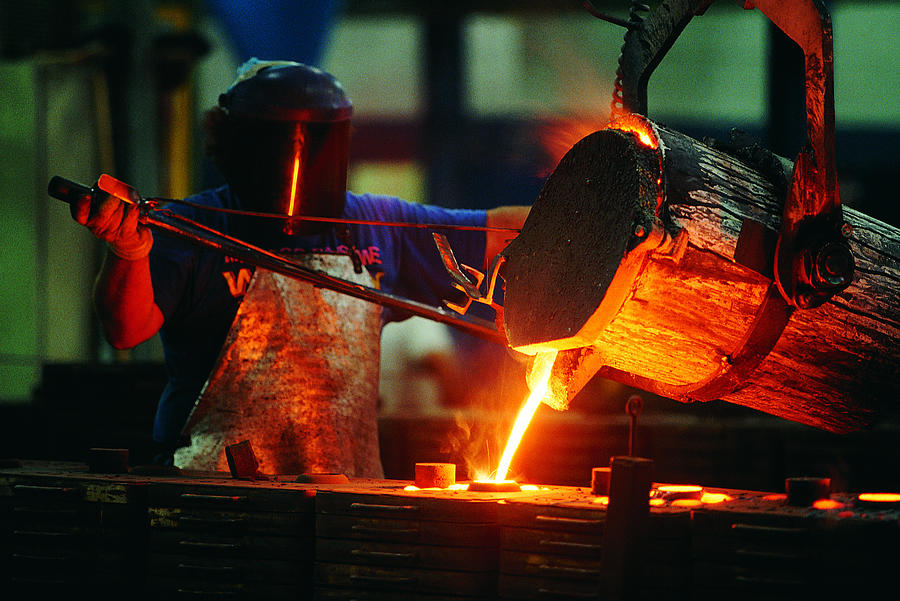 Foundry worker pouring steel Photograph by Photodisc