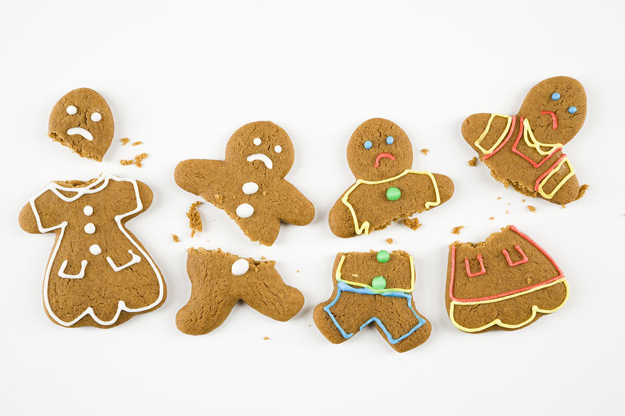 Four frowning male and female gingerbread cookies broken into pieces. Photograph by Fotosearch