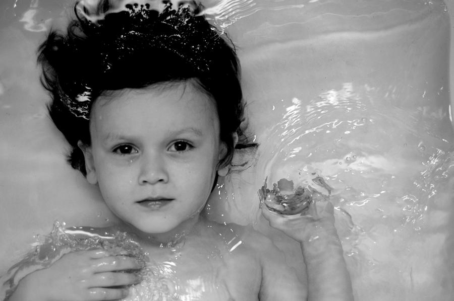 Four year old dark haired boy floating in water Photograph by Meredith Winn Photography
