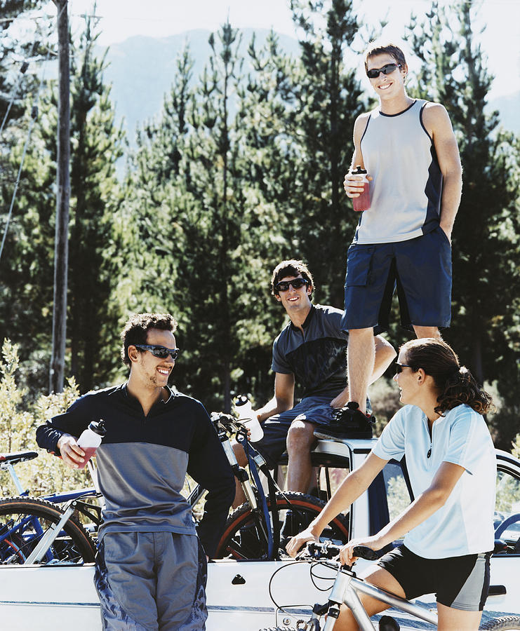 Four Young People Relaxing by an Off Road Vehicle With Their Mountain Bikes Photograph by Digital Vision.