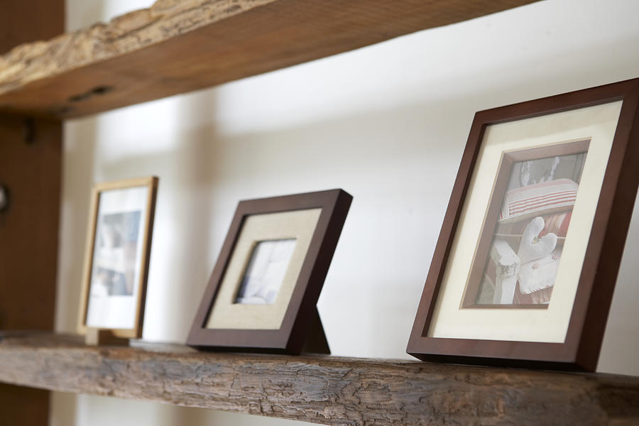 Framed photos on wooden shelf, close-up Photograph by Ultra F