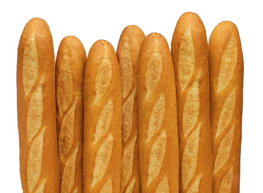 French baguettes stand vertically against a white backdrop Photograph by Tbd
