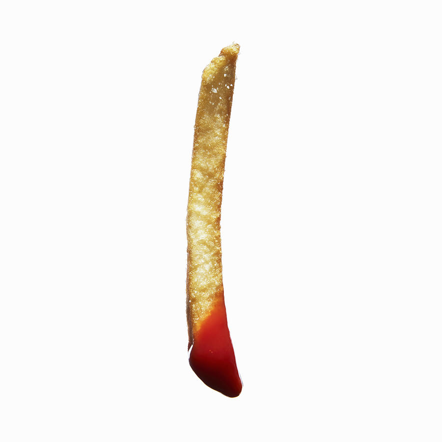 French fry dipped in ketchup Photograph by Maren Caruso