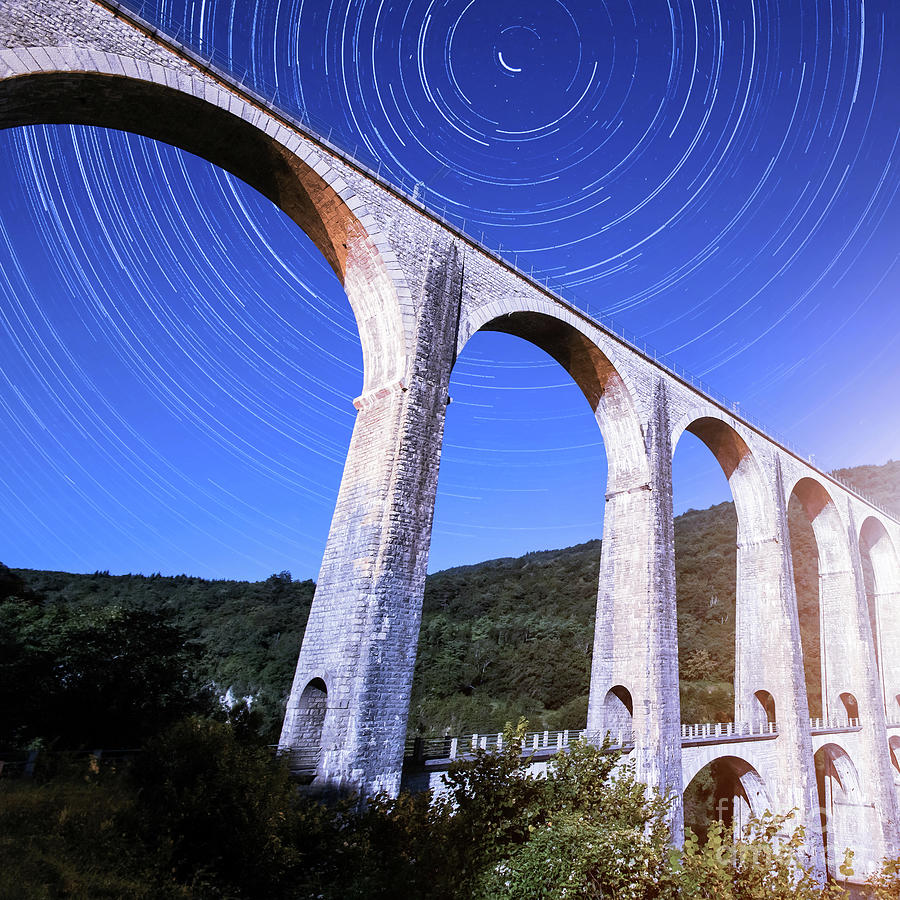French old stone viaduct architecture under moonlight with star trails Photograph by Gregory DUBUS