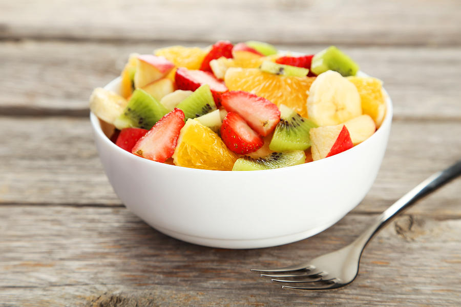 Fresh fruit salad on grey wooden background Photograph by 5second